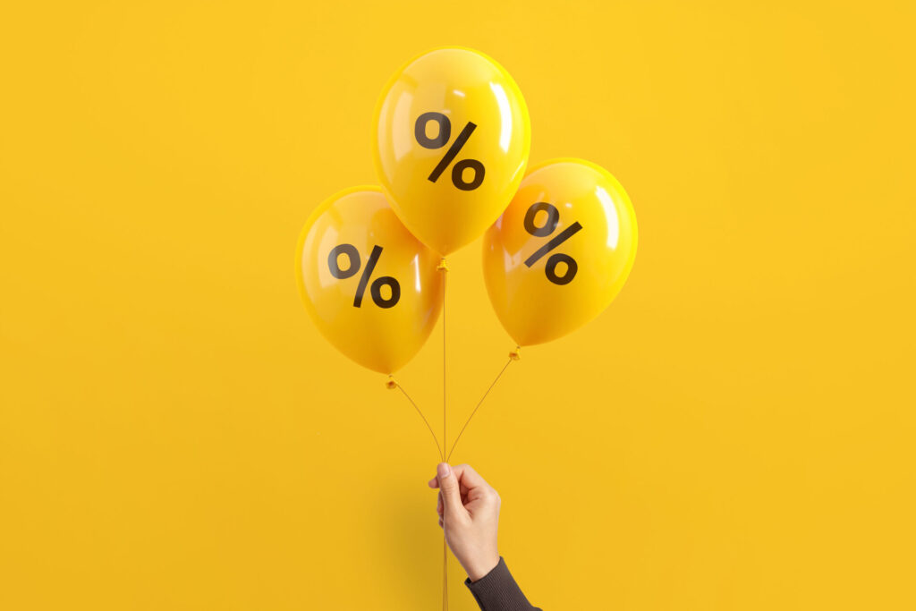 Hand,Of,Woman,Holding,Balloons,With,Percent,On,Yellow,Background,