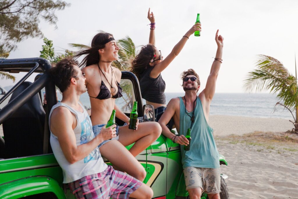 Happy,Friends,Enjoying,Drinks,With,Off road,Vehicle,At,Beach