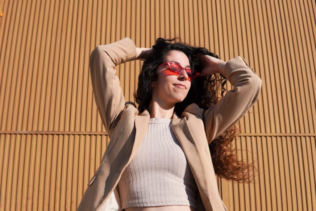 Woman,With,Curly,Hair,Wearing,Red,Sunglasses,On,Sunny,Day