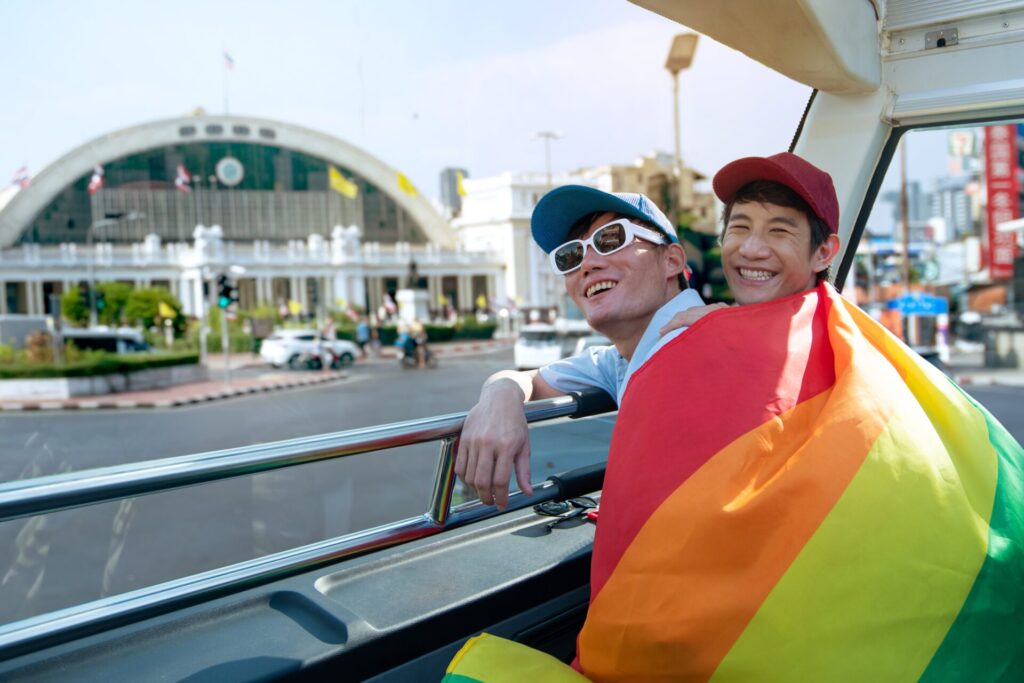 Lgbtq,Couple,With,Rainbow,Flag,Spending,Time,Together,Traveling,On