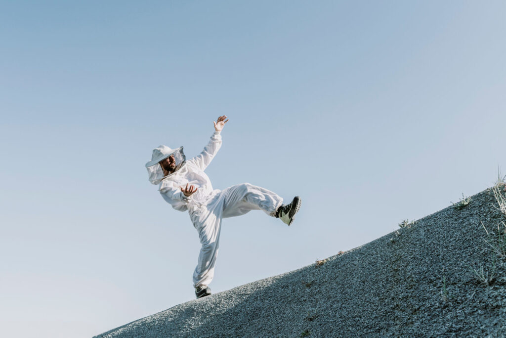 Man,Wearing,A,Beekeeper,Dress,Tumbling,On,A,Hill