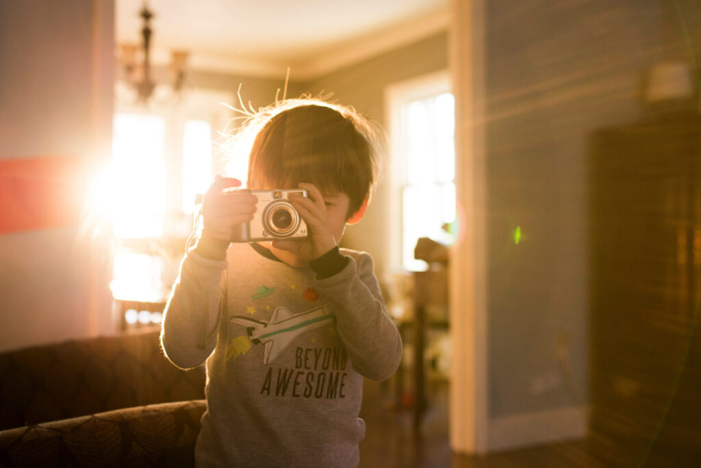 Boy,With,Camera,Taking,A,Picture,Indoors,On,Sunny,Morning