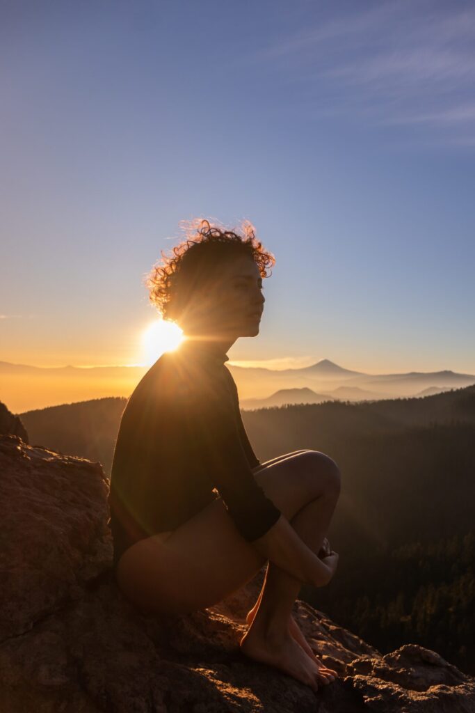 A,Person,With,Curly,Hair,Is,Silhouetted,Against,The,Sun