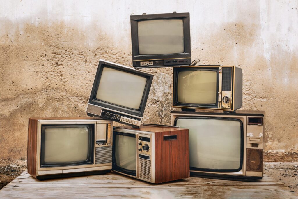 Retro,Old,Televisions,Pile,On,Floor,In,Front,Of,Old