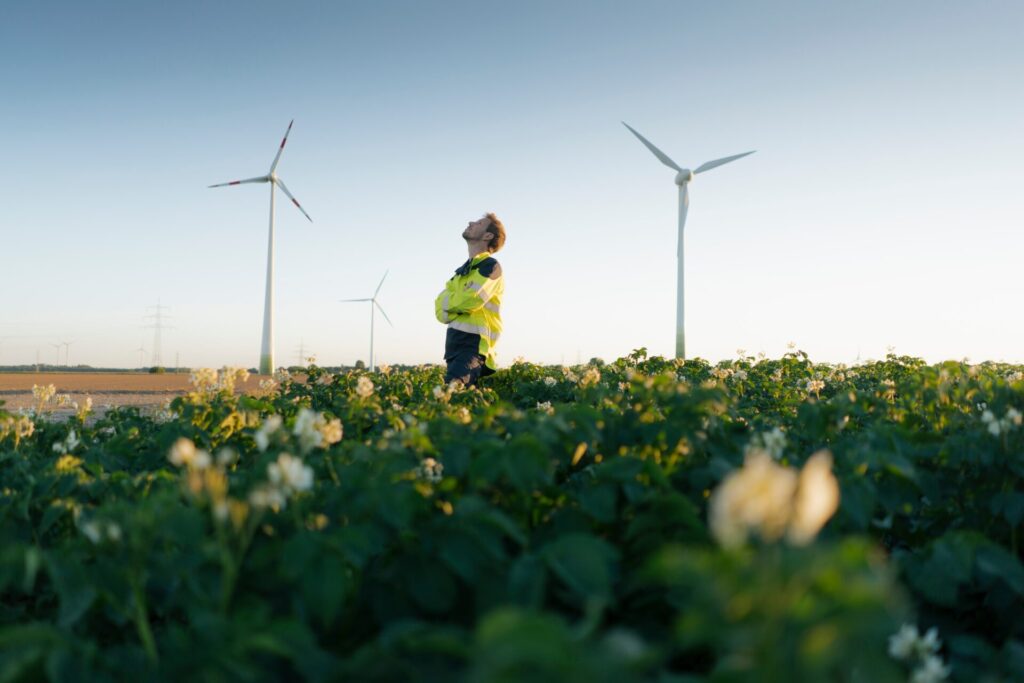 Engineer,Standing,In,A,Field,At,A,Wind,Farm