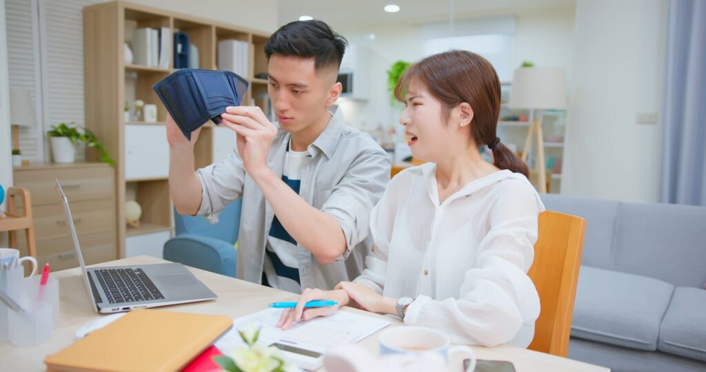 Worried,Asian,Young,Couple,Calculate,Expenses,Finance,Together,With,Laptop